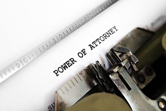 An old-fashioned type-writer and piece of paper. The type says, "Power of Attorney."